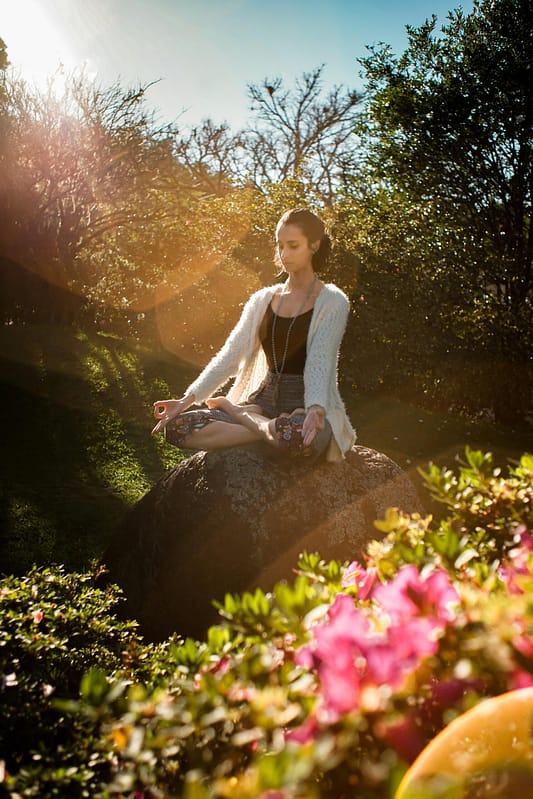 Glockenmeditation auf einer Wiese mit Blumen und Bäumen