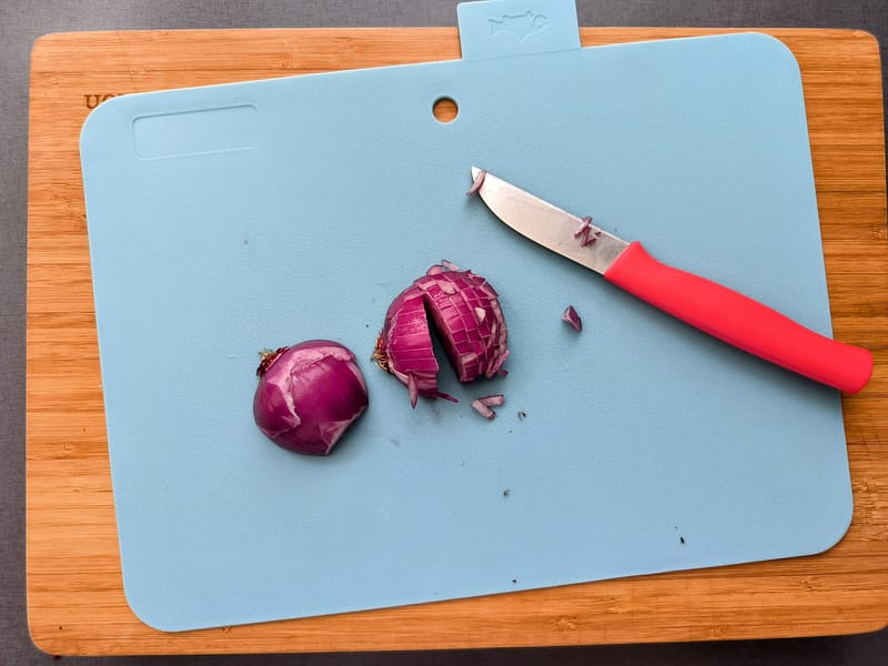 Zwiebeln für das Teriyaki-Sesam-Dressing hacken